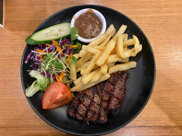 美味的牛排配上新鲜的薯条，沙拉和胡椒酱图片下载