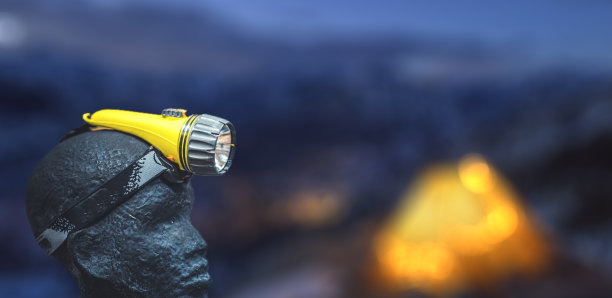 用于固定在头部的LED头灯。山Backround。旅行者探索。图片下载