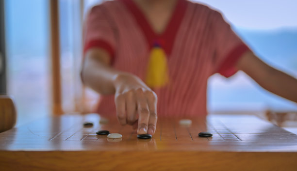 年轻女子在与对方下围棋，这是一种古老的战略性棋盘游戏图片下载