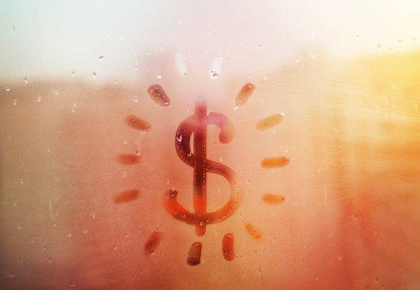 手绘的形状美元图标与光线像太阳文字在泥泞的玻璃潮湿的橙色日落窗口在城市图片下载