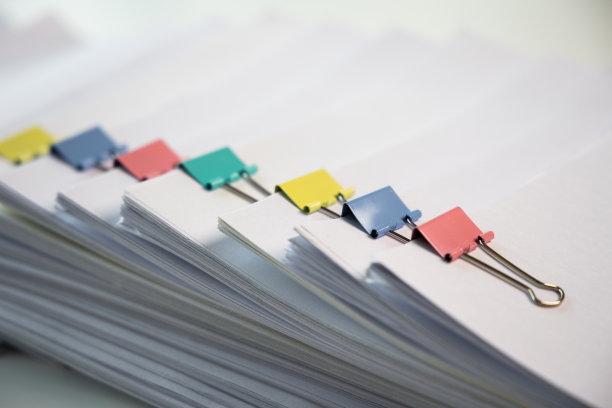成堆的白纸把一大堆文件堆在一起。在办公室的桌子上有彩色的夹子。没有在办公室完成的文件。经营理念。图片下载