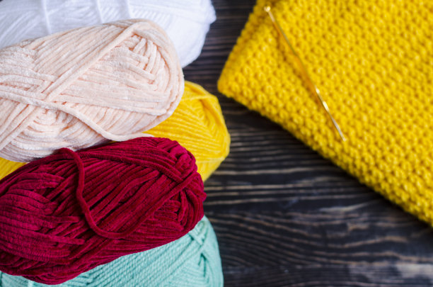 绞色纱线和针织在深色木质背景下的刺绣在自我隔离的背景下编织的概念图片下载