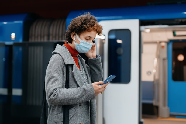 商务女性拿着智能手机走进地铁车厢图片下载