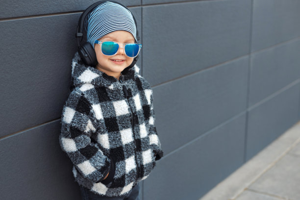 2-3岁的小男孩戴着耳机享受他最喜欢的音乐图片下载