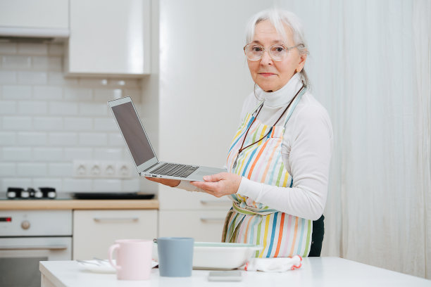 一个老奶奶在厨房里通过电脑上的摄像头聊天，分享图片下载