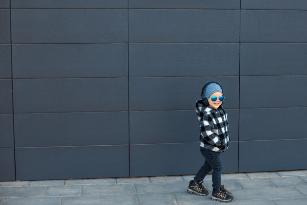 2-3岁的酷小男孩戴着耳机享受他最喜欢的音乐图片下载