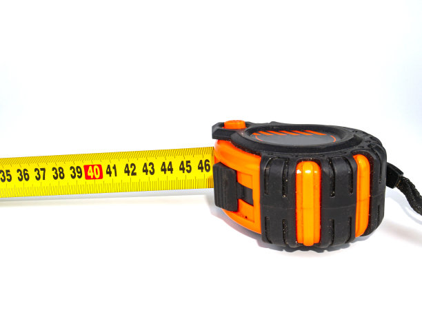 工人在白色背景上测量卷尺。图片下载