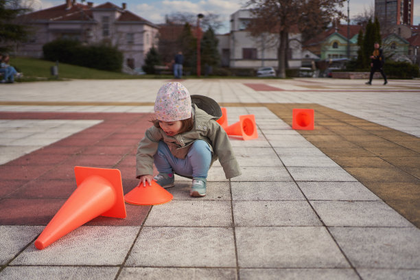 她最近最喜欢的玩具是一个橙色的锥形玩具。她在户外玩得很开心图片下载