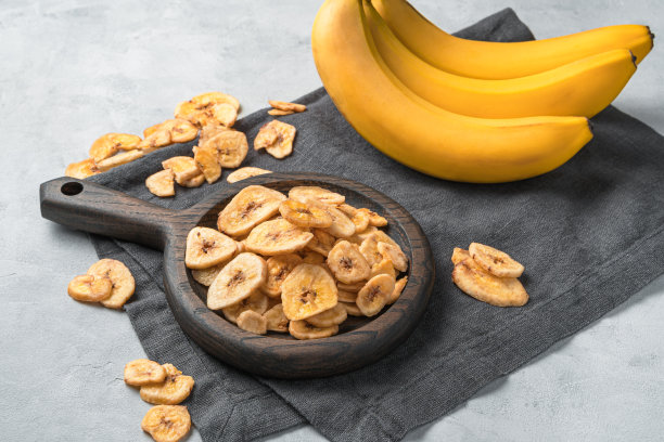 健康的糖果:在新鲜香蕉的背景下的干燥香蕉片图片下载