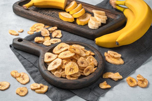 灰色背景上的新鲜香蕉上的香蕉片图片下载