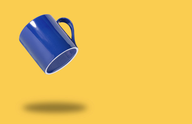 飞行蓝色杯子或马克杯的咖啡或茶在黄色孤立，概念横幅的咖啡店或餐厅，复制空间。图片下载