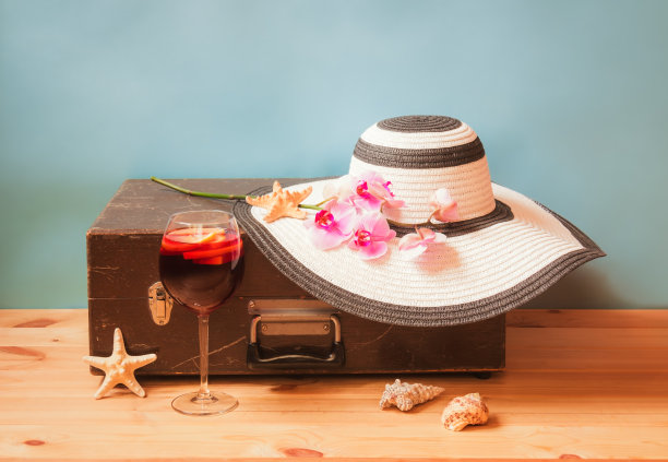 古色古香的木箱，白色的大帽子，一杯桑格利亚汽酒，紫色的兰花，海星和贝壳在蓝色的背景。图片下载