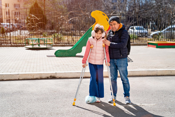 爸爸帮助女儿学习用拐杖走路。把你的脚糊上。图片下载