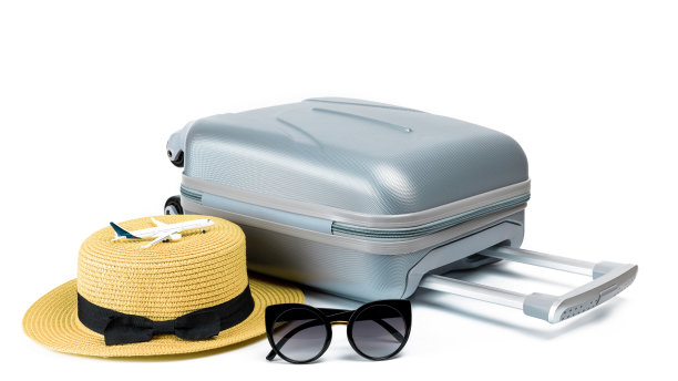 热带的背景。手提箱，带玩具飞机的太阳镜和草帽在白色背景孤立的旅行组成。带有复印空间的异国情调热带海滩。图片下载