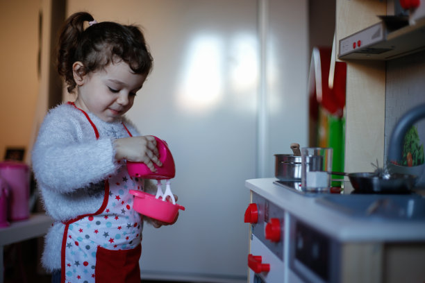 幼小的学前班女孩在玩厨房里的玩具照片图片下载
