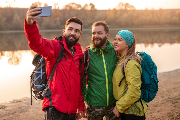 年轻的徒步旅行者在河边自拍图片下载