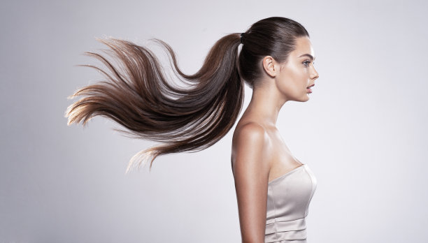 一个长直发的漂亮女人的侧面肖像。图片下载