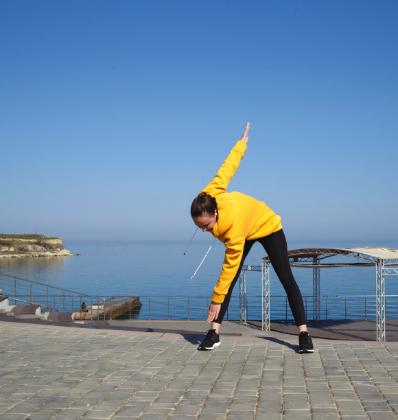 一个年轻女子在海边做户外运动图片下载