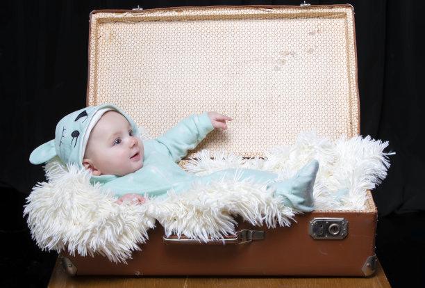 一个小孩躺在复古行李箱里。一个有趣的孩子。4个月大的男孩图片下载