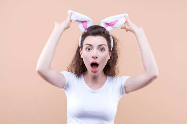带着兔耳朵的有趣女人复活节快乐。图片下载