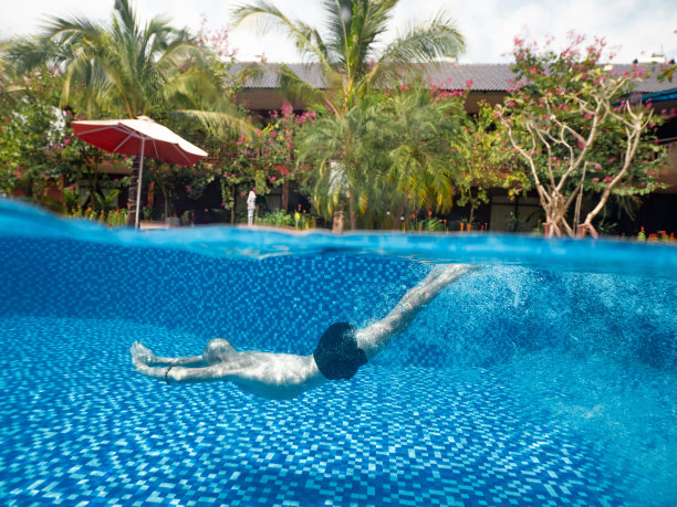 一个男人在度假别墅的游泳池水下的分裂照片图片下载
