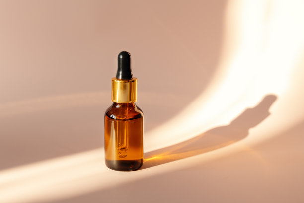 装有精油或精华液的玻璃瓶，光线强，阴影深，拷贝空间大。皮肤护理的概念图片下载