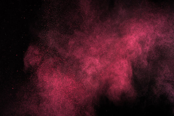 红色粉末在黑色背景上爆炸。图片下载