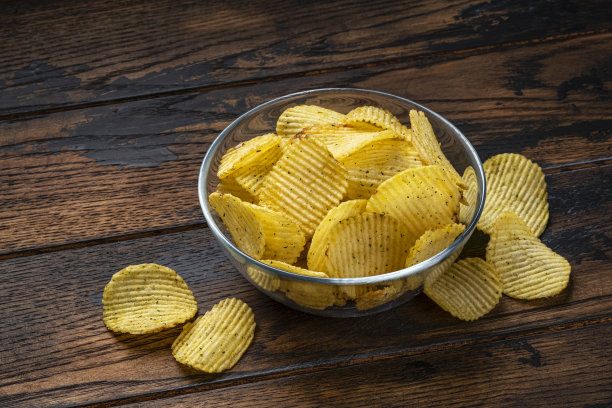 脊薯片在碗在木制背景图片下载