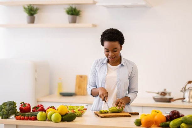 享受烹饪休闲的女士在厨房切蔬菜做沙拉图片下载