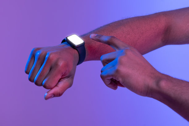 一名非裔美国男性在霓虹灯下使用黑屏智能手表图片下载