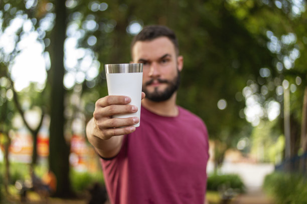 一个年轻人在公园里拿着一块钢玻璃图片下载