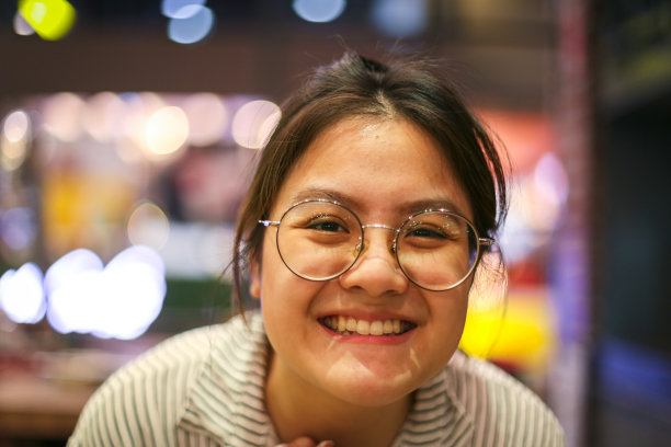 亚洲女孩戴眼镜微笑与夜晚的花束背景图片下载