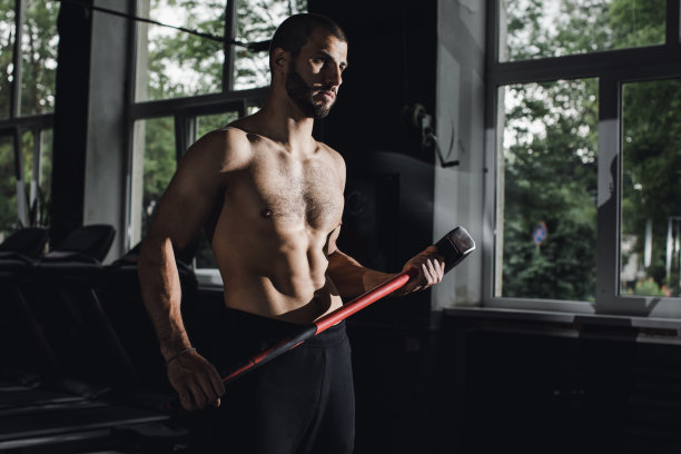 英俊的健美运动员闭着眼睛在健身房做大锤运动后休息。全长侧视图照片图片下载