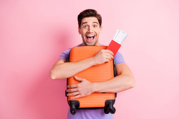 照片的年轻兴奋的男子幸福积极的微笑拥抱包持护照机票飞飞机国外孤立在淡雅的颜色背景图片下载