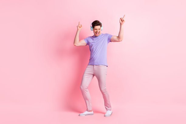 完整的照片的年轻开朗的家伙兴奋疯狂的舞蹈听音乐耳机隔离在柔和的颜色背景图片下载