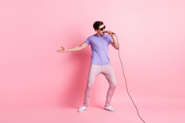 全尺寸照片的年轻兴奋的男人快乐积极享受唱歌麦克风音乐会孤立在粉红色的背景图片下载