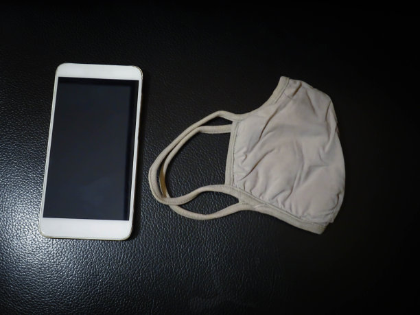 沙发上放着智能手机和口罩图片下载
