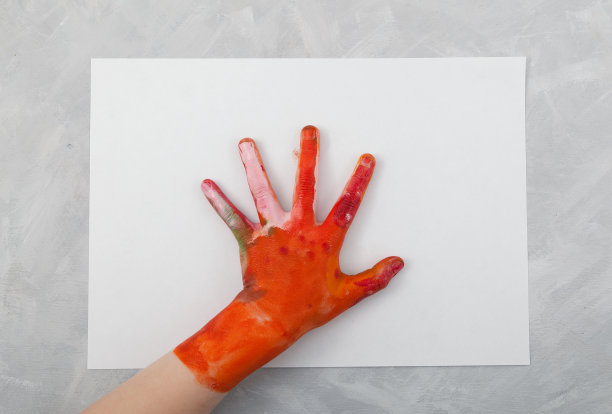 孩子的手在白纸上画画。孩子们的创造力。给孩子画手指画。灰色表，复制空间图片下载