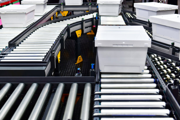 传送带上的白色塑料盒。包裹运输系统概念图片下载