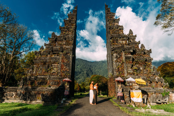 巴厘岛寺庙里的漂亮情侣。一男一女在印度尼西亚旅行。一对夫妇在巴厘岛门口。这对夫妇周游世界。去亚洲的旅游胜地旅游。游客在巴厘岛。副本的空间。图片下载