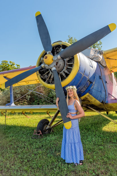 一个可爱的女人站在飞机旁边。戴花环的妇女头上戴着花环的妇女图片下载