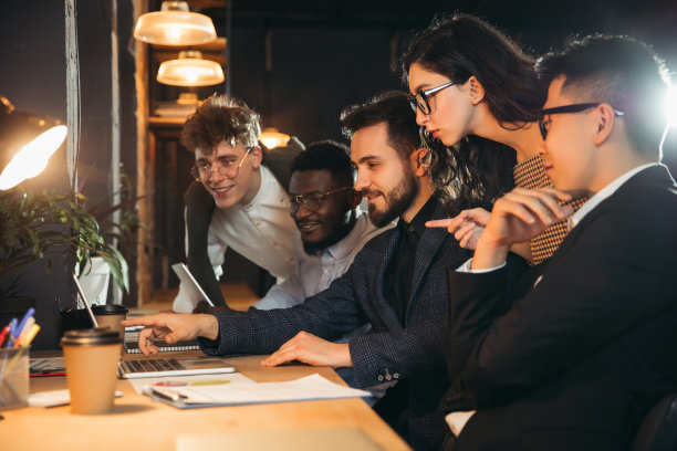 同事在现代的办公室里一起工作，在创意会议期间使用设备和小工具图片下载