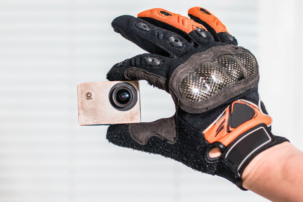 一个戴着自行车手套的人用右手在运动相机上自拍。图片下载