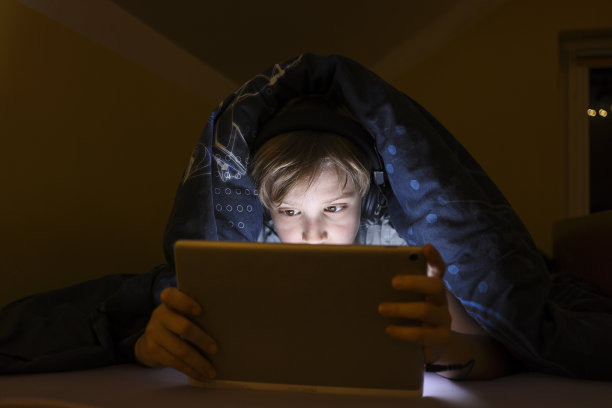 小男孩睡觉后看动画片图片下载