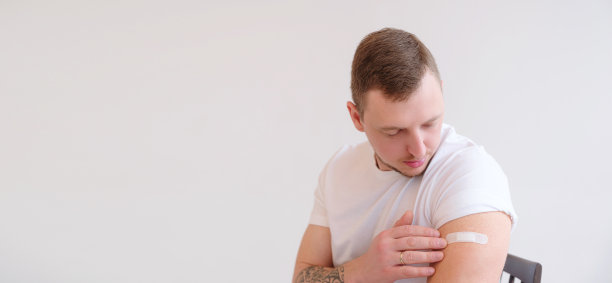 接受covid-19疫苗接种后微笑的白人男子。图片下载