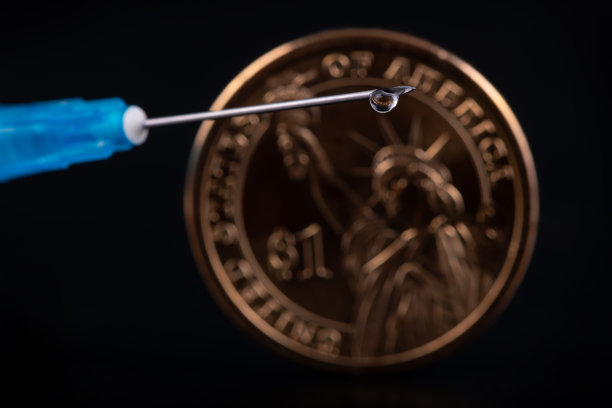 一次性注射器，针头上滴一滴，黑色背景上有1美元硬币图片下载