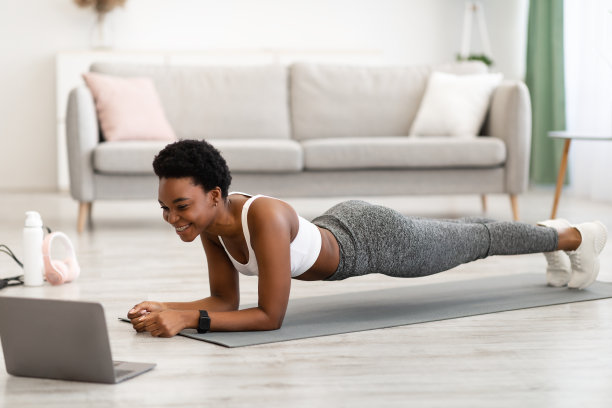 运动非洲女性在笔记本电脑训练站在室内平板图片下载