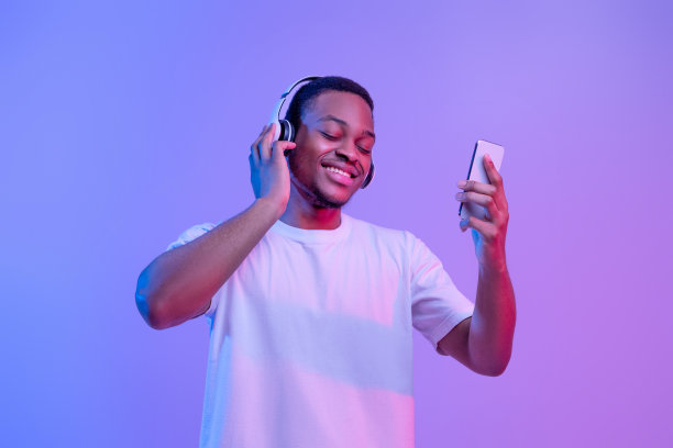 年轻的非洲裔美国人用无线耳机在智能手机上听音乐图片下载