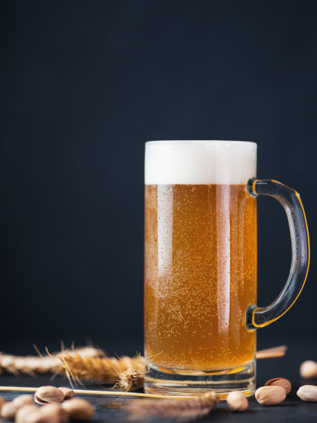 黑墙边放着一大杯小麦啤酒。麦穗、开心果拷贝空间图片下载