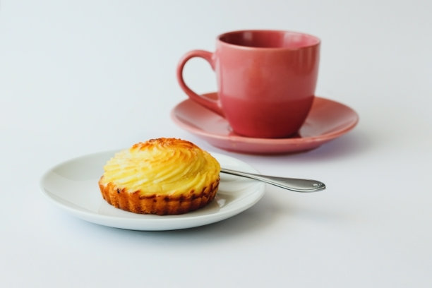 软干酪蛋糕和一杯茶放在盘子里。极简主义图片下载